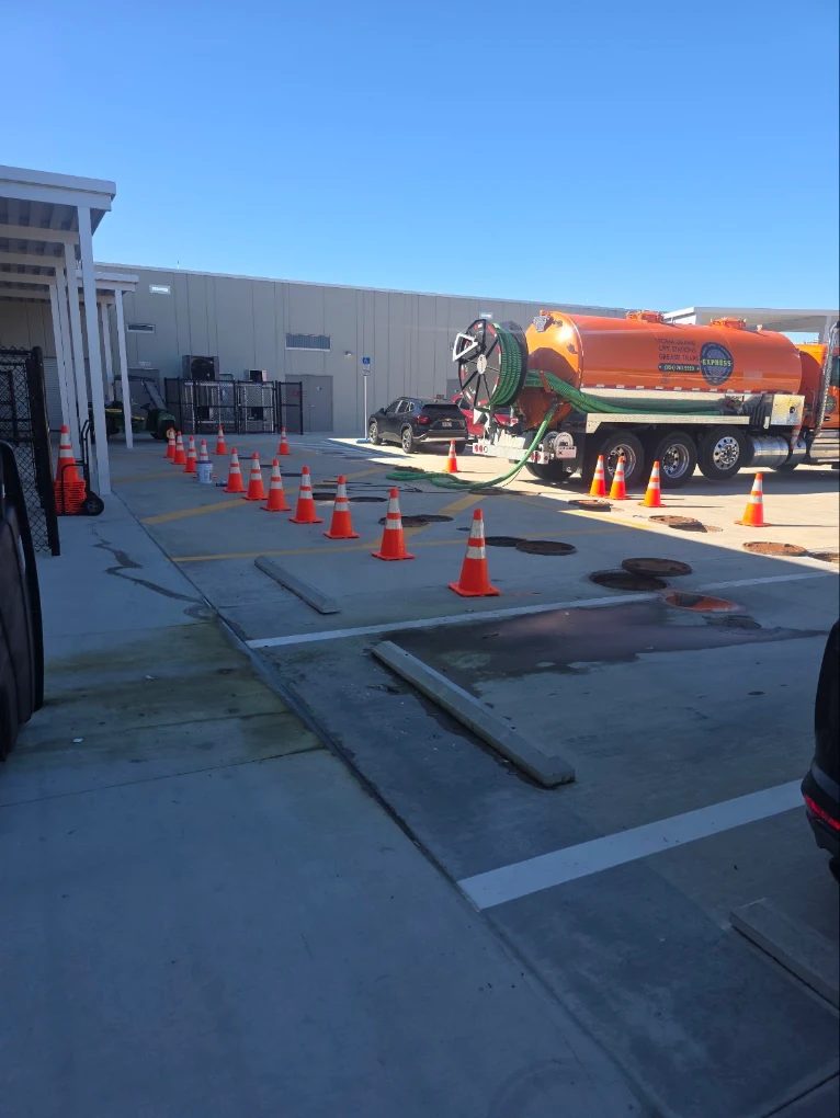 Vacuum tanker truck and safety cones beside service access covers