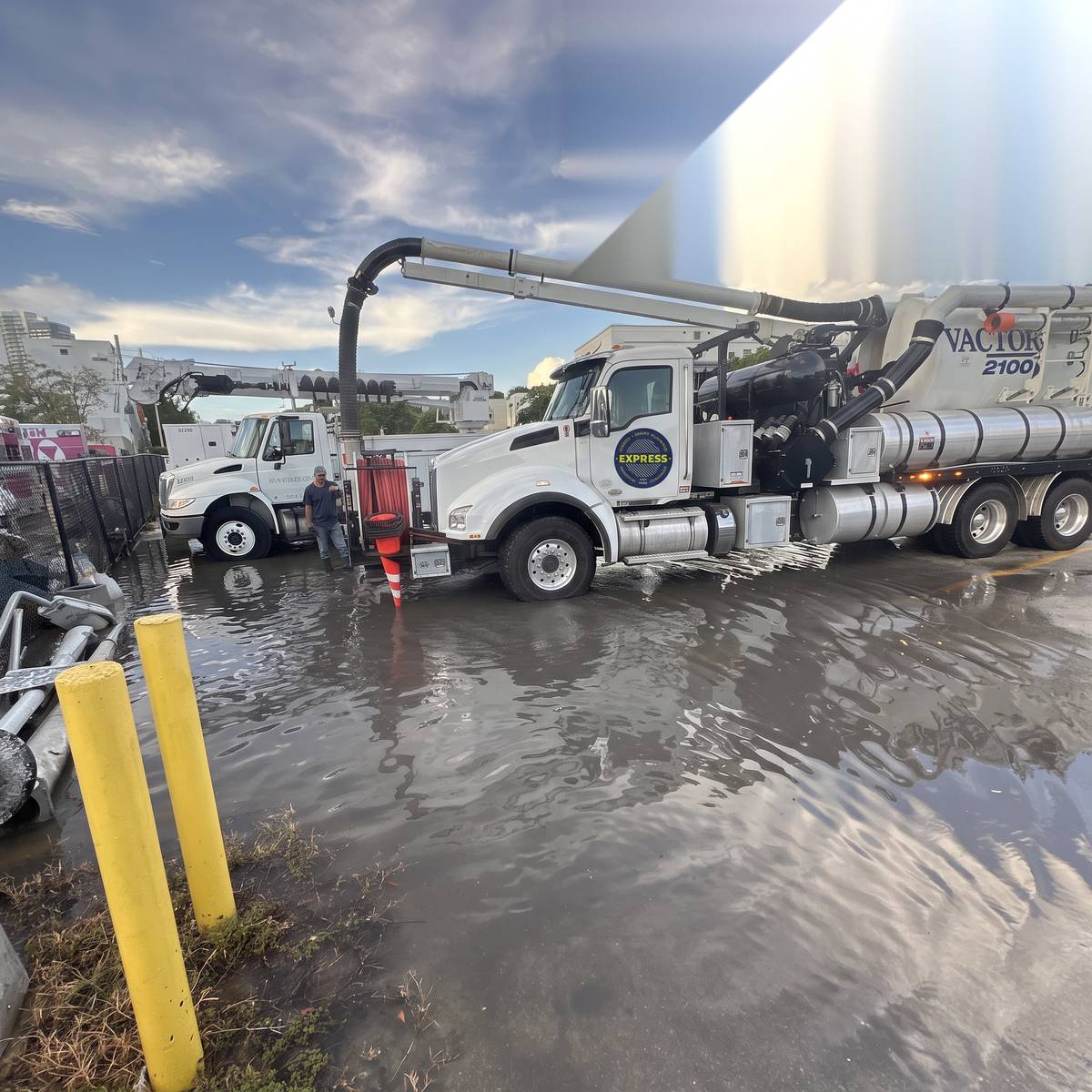 White Express vacuum truck with its boom extended at a wet job site